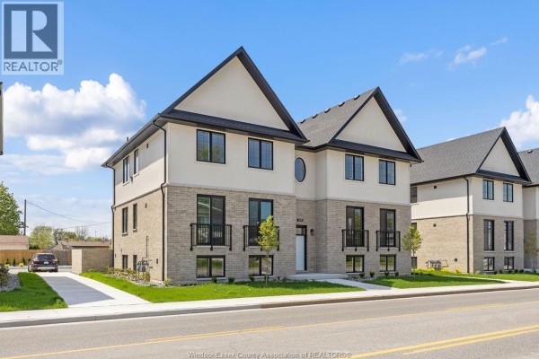 Side view of the apartment building showing a driveway and additional units. - 1401 Lesperance, Tecumseh