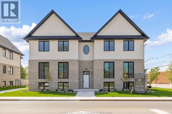 Front view of the apartment building with a "Now Leasing" sign. - 1401 Lesperance, Tecumseh