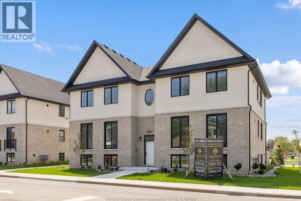 Right side of the apartment building from the street, with a leasing sign visible. - 1401 Lesperance, Tecumseh