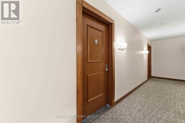 Long hallway with multiple apartment doors and sconces on the walls. - 1402 - 195 Besserer Street, Ottawa
