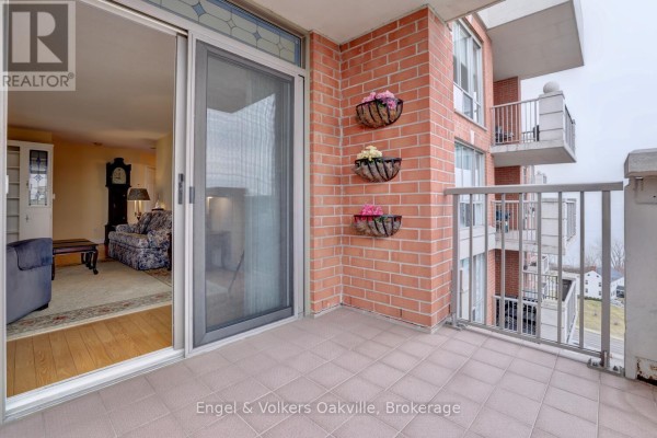 Balcony with brick walls and planters, view of living room with grandfather clock - 1402 - 442 Maple Avenue Burlington