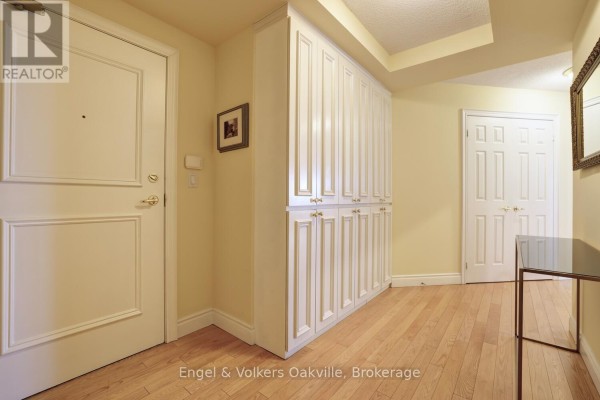 Hallway with built-in cabinets and hardwood floors - 1402 - 442 Maple Avenue Burlington