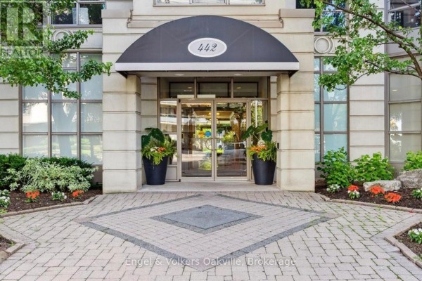 Building entrance with double glass doors, black awning, and potted plants - 442 Maple Avenue Burlington