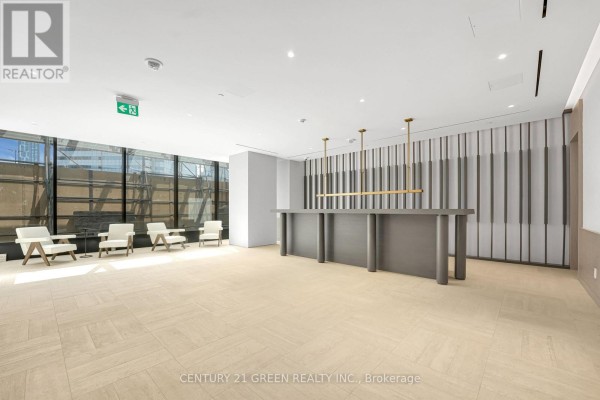 Building lobby with a long reception desk, chairs, and vertical metal wall panels. - 1403 - 4015 The Exchange, Mississauga