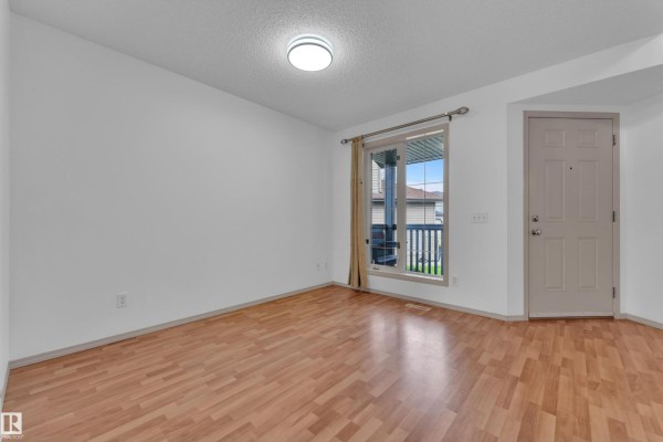 Office space with a large bookshelf, two chairs, and a tan sofa. - 14031 136 St Nw, Edmonton