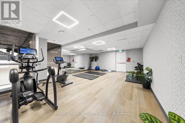 Fitness center with cardio equipment, yoga mats, and mirrors. - 1404 - 161 Laurier Avenue W, Ottawa