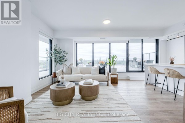 Open-concept living area with white walls, light wood floors, and large windows. - 1404 - 36 Brentcliffe Road, Toronto