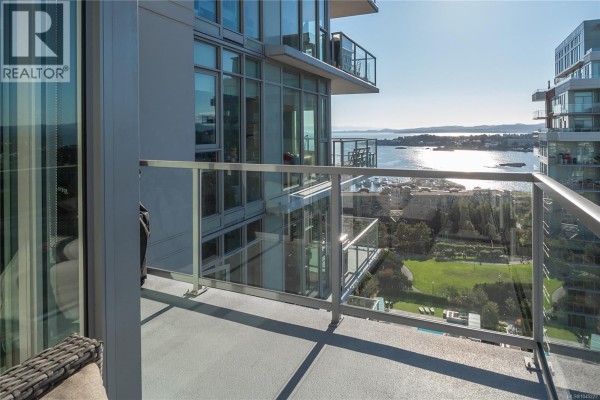 Balcony view from apartment with glass railings overlooking water and city. - 1404 83 Saghalie Rd, Victoria