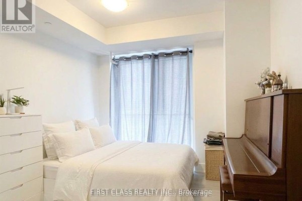 Second bedroom with queen bed, white bedding, dresser, and piano. - 1405 - 200 Bloor Street W, Toronto