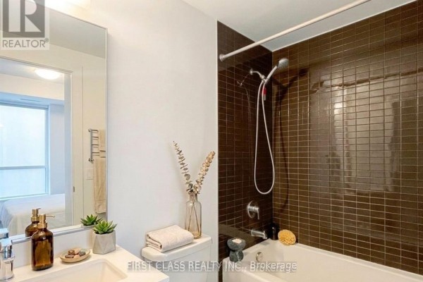 Bathroom with bathtub, tiled shower surround, vanity, and toilet. - 1405 - 200 Bloor Street W, Toronto