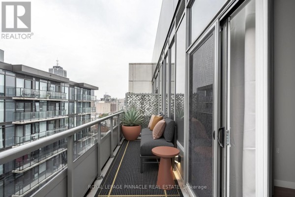 Covered outdoor lounge area on the rooftop terrace with seating, fire pits, and a view of the city. - 1405 - 212 King William Street, Hamilton