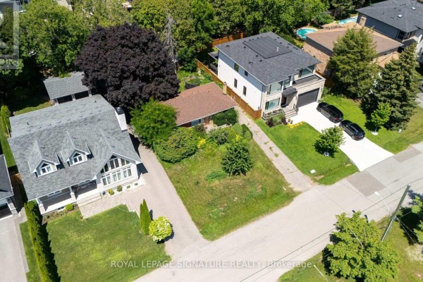 Aerial view of the property lot with adjacent houses, showing the bungalow situated between two larger modern homes. - 1405 Constance Drive, Oakville