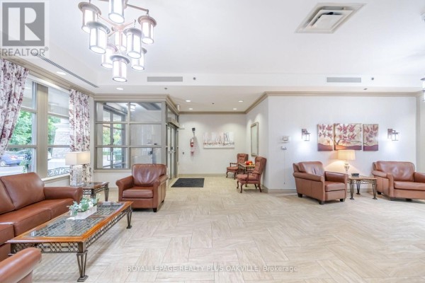 Lobby with brown leather sofas, armchairs, glass coffee tables, and patterned curtains. - 1406 - 100 Burloak Drive, Burlington