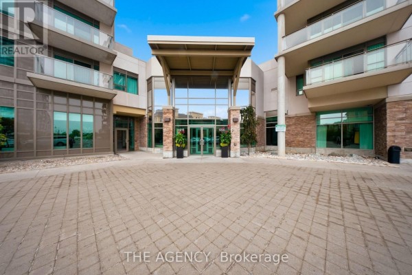 Entrance to an apartment building with a paved walkway and covered entryway. - 1406 - 1215 Bayly Street, Pickering