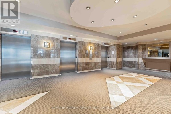 Elevator bank in the lobby of 199 Kent Street, Ottawa, with stainless steel doors and marble walls. - 1409 - 199 Kent Street, Ottawa