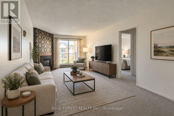 Living room with a beige sofa, fireplace, television, and a sliding glass door. - 141 - 1096 Jalna Boulevard, London South