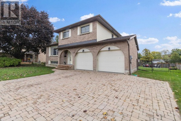 Side view of a two-story brick house with a paved driveway and a manicured lawn. - 141 Beley Street, Brockville