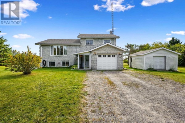 Front facade of a grey brick two-story house with large bay windows and an attached garage. - 141 Cedar Lane, Cramahe
