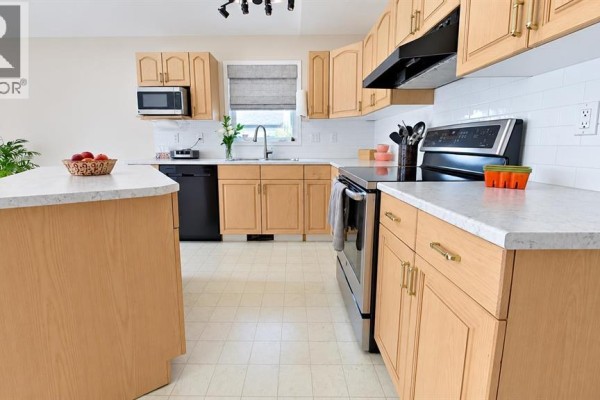 Kitchen with light wood cabinets, white subway tile backsplash, stainless steel appliances, and a light countertop. - 141 Eglert Drive, Fort Mcmurray