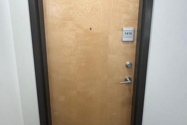 Close-up of apartment door with number 1410 and a silver handle. - 1410 - 100 Garment Street N, Kitchener