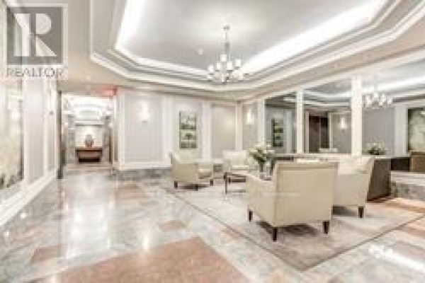 Luxurious building lobby with marble floors, elegant seating, and chandeliers. - 1410 - 24 Wellesley Street W, Toronto
