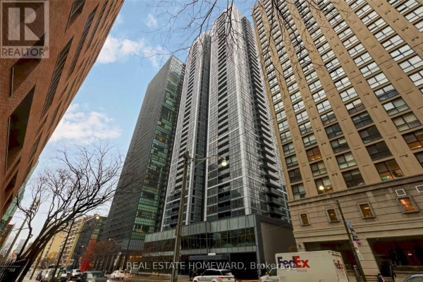 Exterior view of a modern condominium tower from street level, surrounded by other buildings. - 1410 - 28 Ted Rogers Way, Toronto