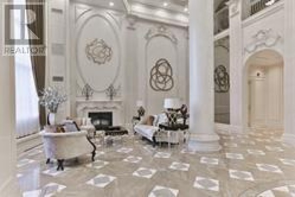 Lobby seating area with a fireplace, plush sofas, and decorative wall accents. - 1410 - 9245 Jane Street, Vaughan