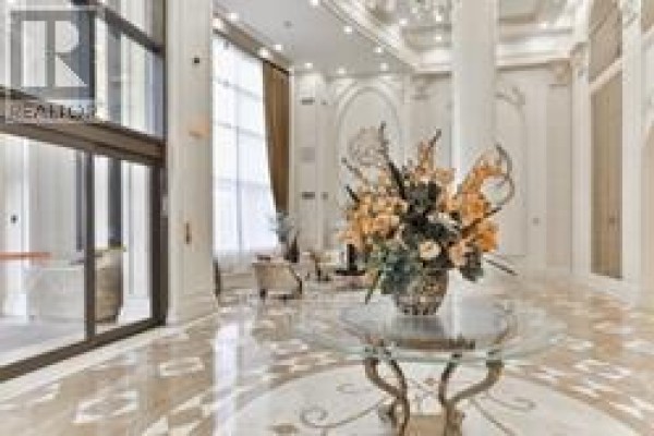 Bright, spacious lobby with a large floral arrangement on a glass-top table. - 1410 - 9245 Jane Street, Vaughan