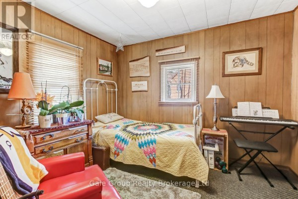 Kitchen with a white stove, microwave, round wooden table, and chairs. - 1410 Dundas Street, Woodstock