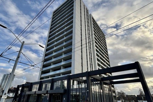 Exterior view of a modern high-rise apartment building with balconies and dark framing, seen from a low angle. - 1412 - 741 King Street W, Kitchener