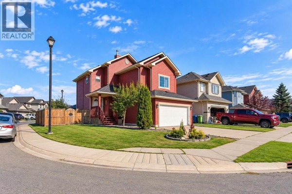 Side view of a red house with a two-car garage on a corner lot. - 1412 Bayside Avenue Sw, Airdrie
