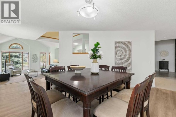 Dining room featuring a dark wood table with six chairs and artwork on the wall. - 14125 Evergreen Street Sw, Calgary