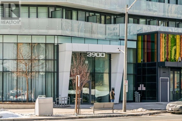 Entrance of 3900 Confederation Parkway featuring large glass windows and colorful accents. - 1413 - 3900 Confederation Parkway, Mississauga