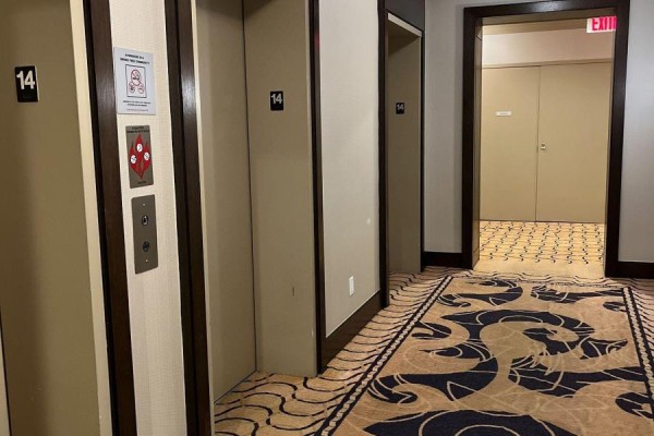 Hallway on the 14th floor with elevator doors and patterned carpet. - 1414 - 100 Harrison Garden Boulevard, Toronto