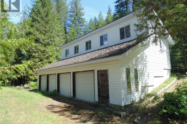 White house with a multi-car garage and wood shingle roof. - 1415 Bridge Road, Crescent Valley