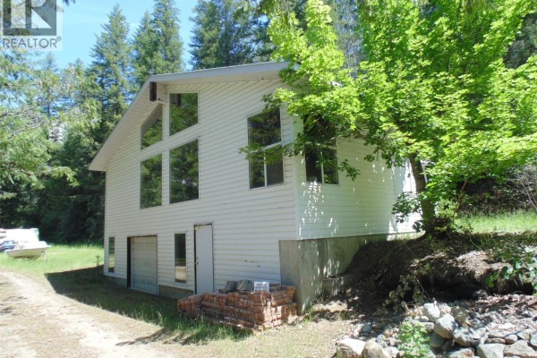 White house with large windows on two levels and a concrete foundation. - 1415 Bridge Road, Crescent Valley
