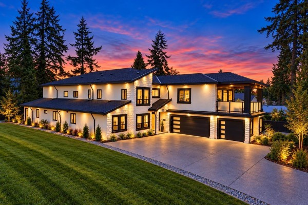 Aerial view of a large modern house with manicured lawn at dusk. - 14186 Melrose Drive, Surrey