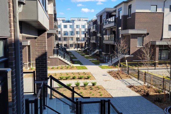 Courtyard view of modern townhouse complex with paved walkways and landscaping. - 1419 - 1695 Dersan Street, Pickering