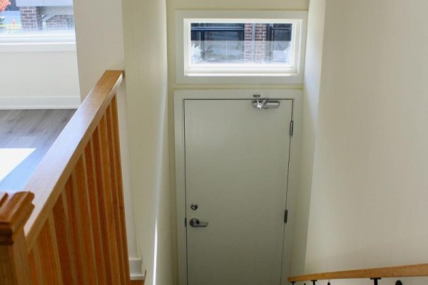 Interior view looking down at a white door at the bottom of stairs. - 1419 - 1695 Dersan Street, Pickering