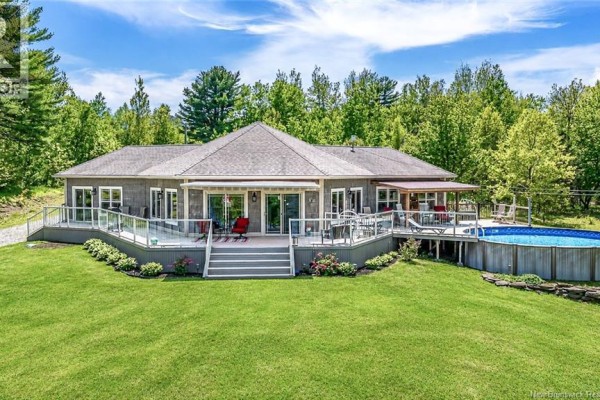 Open concept kitchen and dining area with a large dining table, pendant lighting, and a view of the outdoors. - 1419 102 Route, Upper Gagetown