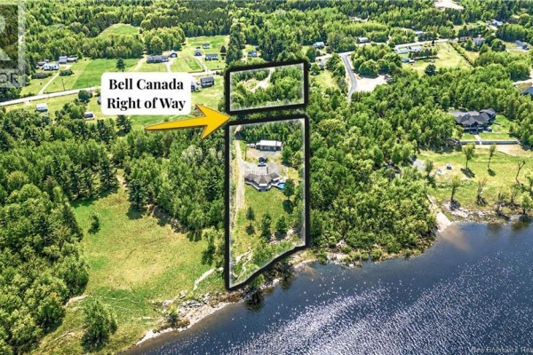 Bathroom with a walk-in glass shower, toilet, dark wood vanity, and a window overlooking the trees. - 1419 102 Route, Upper Gagetown