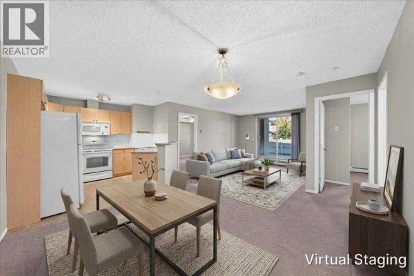 Living room and dining area with beige carpet, light grey walls, and kitchen. - 142, 428 Chaparral Ravine View Se, Calgary