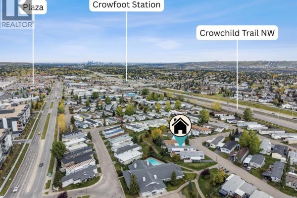 Aerial view of a mobile home community with a distant city skyline, highlighting nearby amenities and roadways. - 142, 99 Arbour Lake Road, Calgary