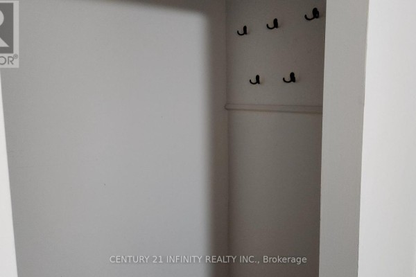 Empty closet space with multiple black hooks mounted on the wall. - 142 Simcoe Street S, Oshawa
