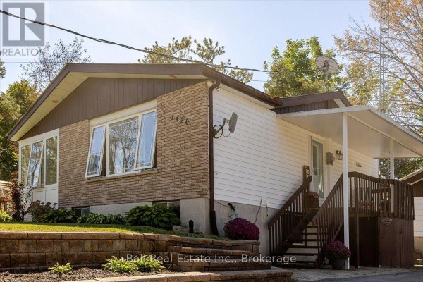 Close-up view of the front entrance, porch, and brick facade of the bungalow. - 1420 Eastview Drive, Selwyn