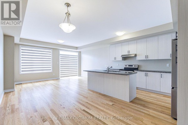 Laundry room featuring a utility sink and stacked washer-dryer - 1420 Oakmont Common, Burlington