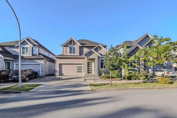 Front view of a beige and grey two-story house with a two-car garage on a paved driveway. - 14215 61b Avenue, Surrey