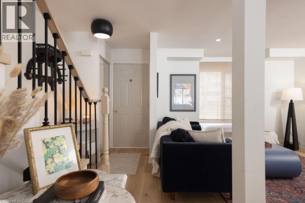 Entrance area with pale grey door, staircase, and framed art on the wall. - 1422 Ghent Avenue, Burlington