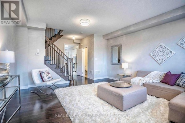 Living room with a sectional sofa, white shag rug, and dark hardwood floors. - 1424 Granrock Crescent, Mississauga