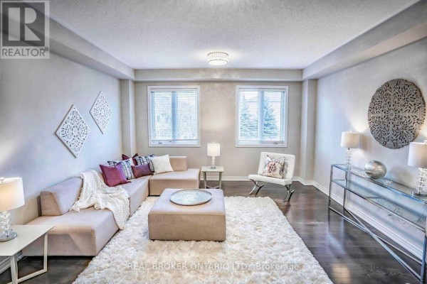 Living room with a sectional sofa, white shag rug, and two windows. - 1424 Granrock Crescent, Mississauga